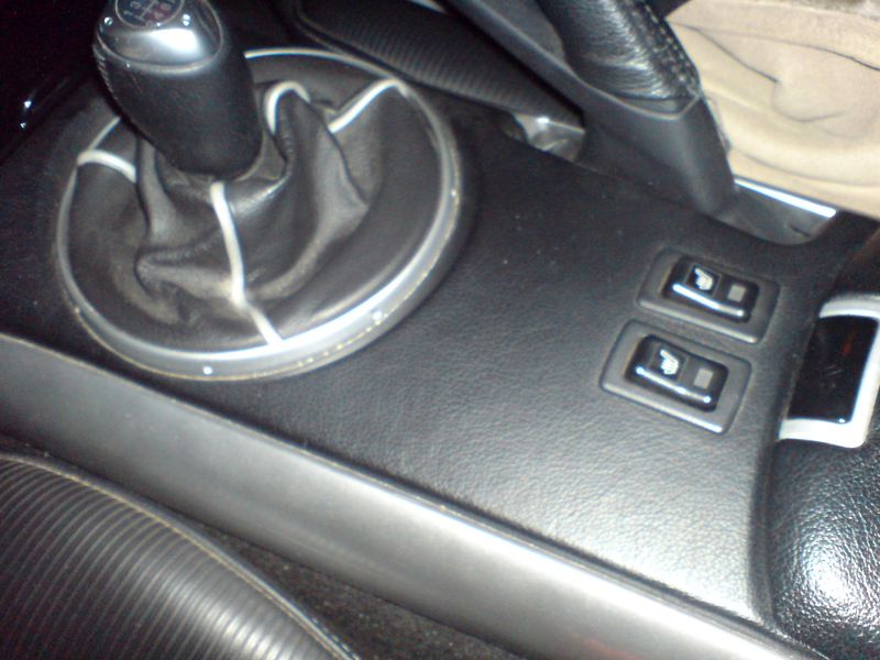 console centrale en cuir, souflet en cuir, les deux accoudoir en cuir et le frein a main en cuir